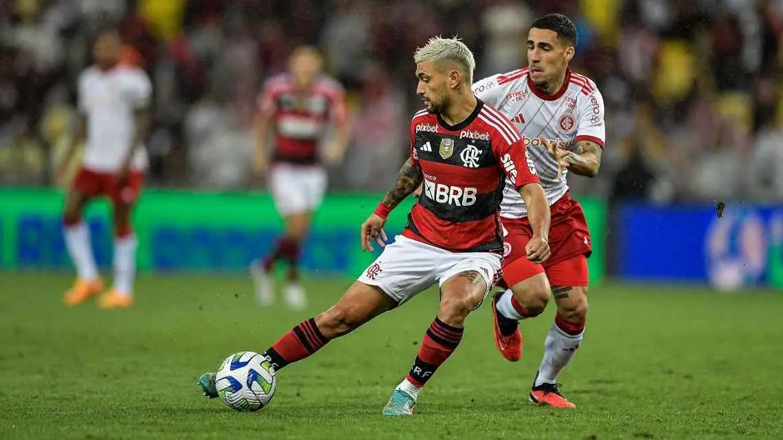 Arrascaeta e Gabriel disputam bola no meio-campo em partida entre Flamengo e Internacional