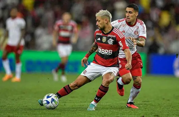 Arrascaeta e Gabriel disputam bola no meio-campo em partida entre Flamengo e Internacional (Foto: Thiago Ribeiro/ Agif/Gazeta Press)
