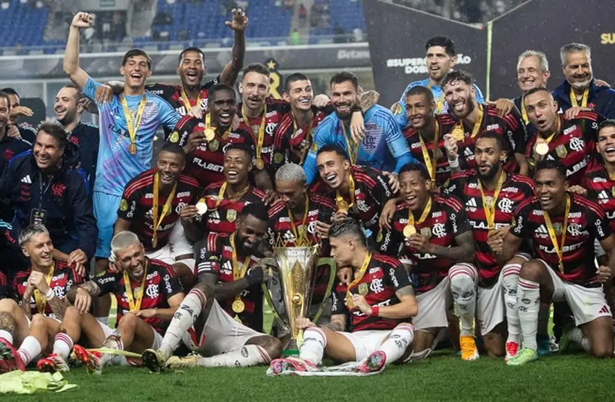 Time do Flamengo comemora com troféu da Supercopa